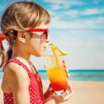 bambina beve in spiaggia